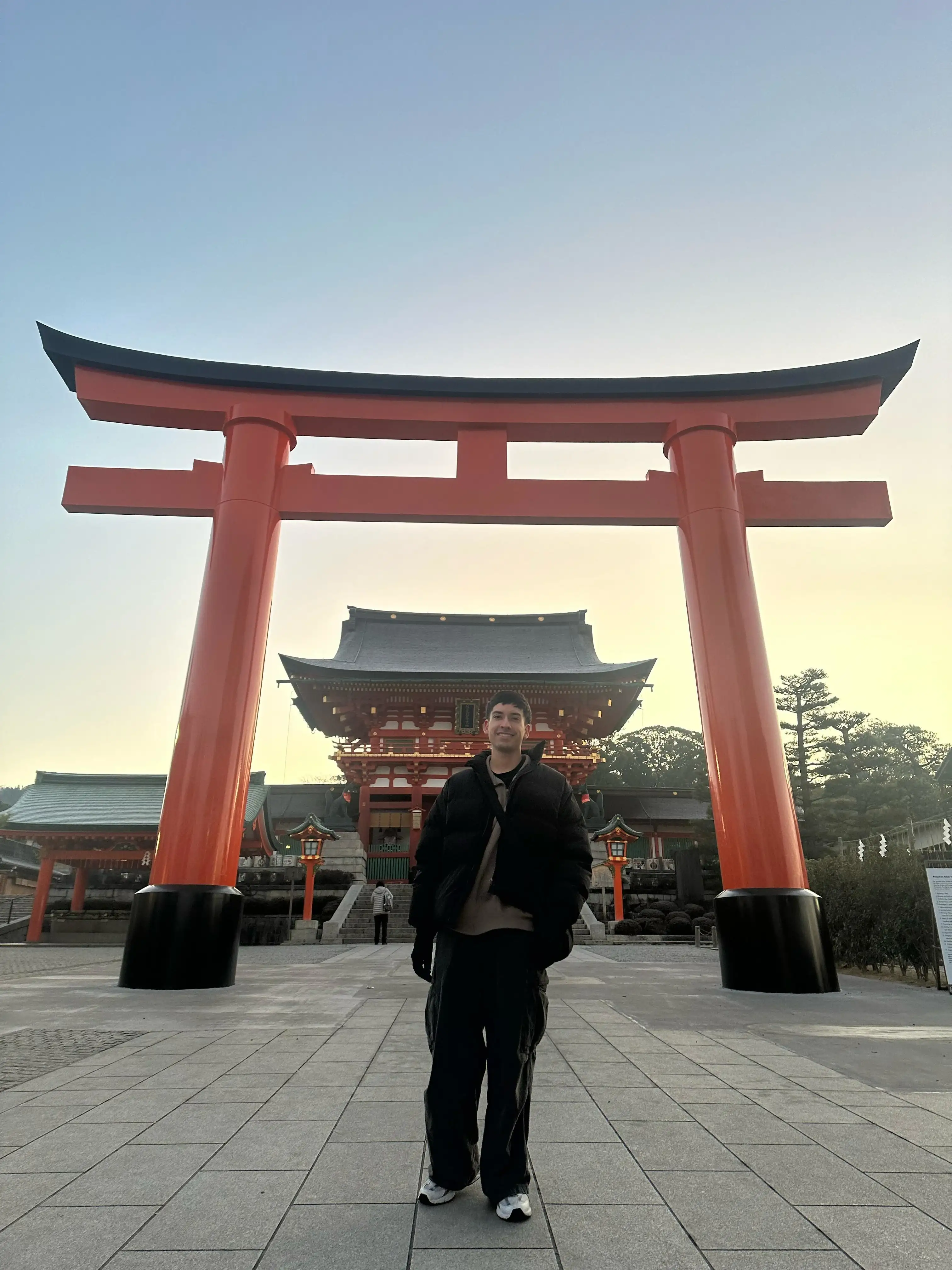 Voluntario en frente de un puerta Torii